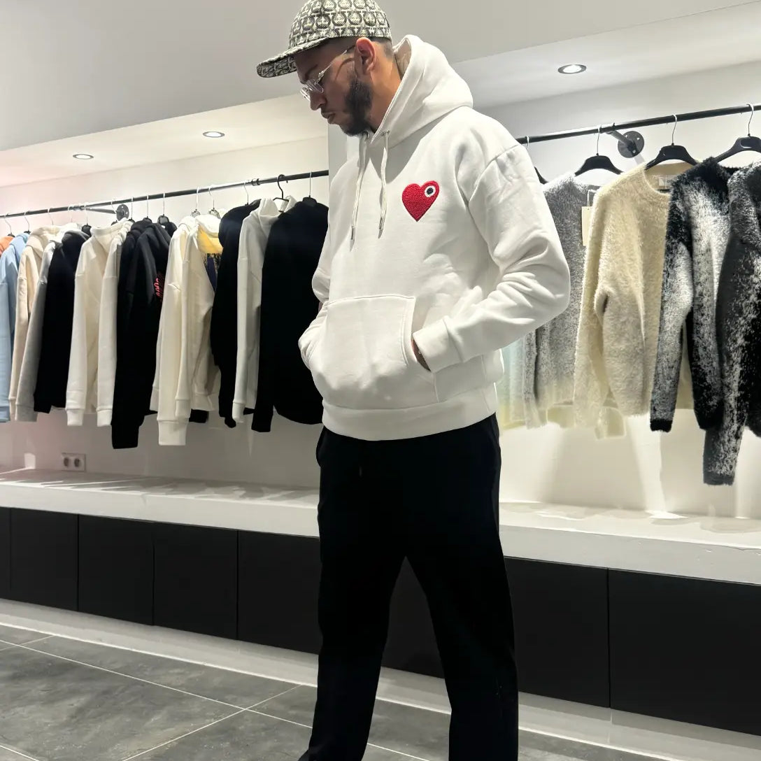 Modèle debout montrant la shape complète et le tombé impeccable du pull ADJ blanc en coupe classique.