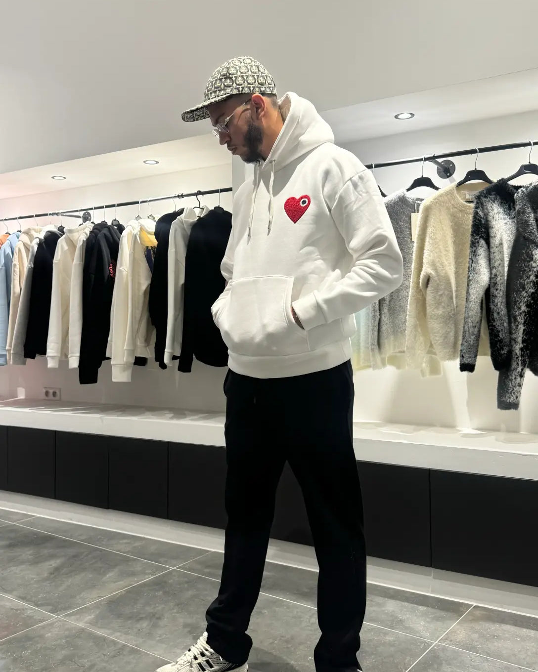 Modèle debout montrant la shape complète et le tombé impeccable du pull ADJ blanc en coupe classique.