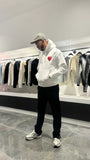 Modèle debout montrant la shape complète et le tombé impeccable du pull ADJ blanc en coupe classique.
