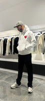 Modèle debout montrant la shape complète et le tombé impeccable du pull ADJ blanc en coupe classique.