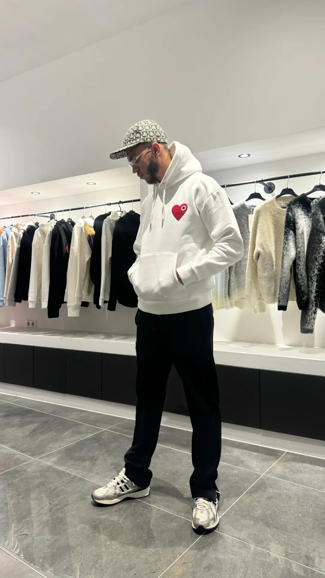 Modèle debout montrant la shape complète et le tombé impeccable du pull ADJ blanc en coupe classique.