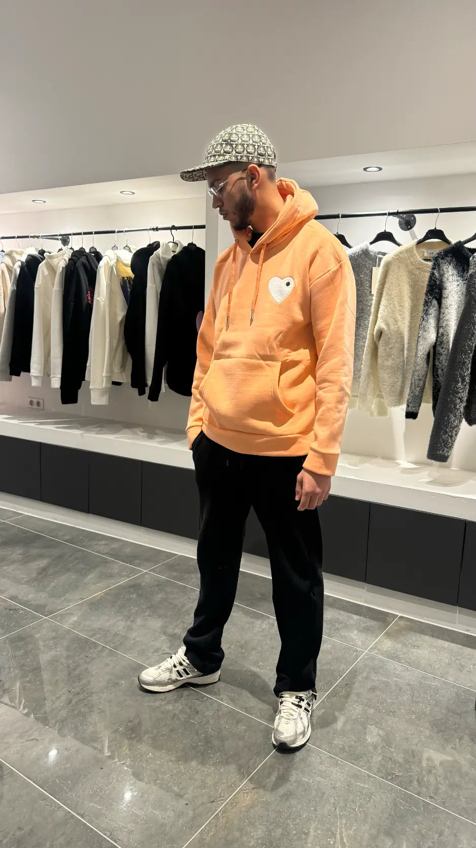 Modèle debout présentant la shape et le tombé du pull ADJ orange clair en coupe classique.