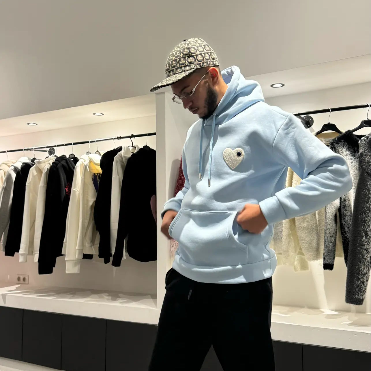 Modèle debout exposant la shape complète et la coupe classique du pull ADJ bleu clair en lumière naturelle.