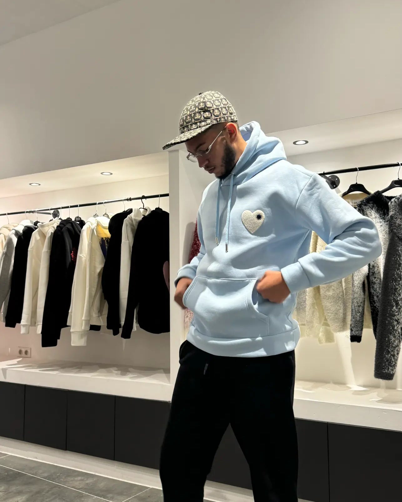 Modèle debout exposant la shape complète et la coupe classique du pull ADJ bleu clair en lumière naturelle.