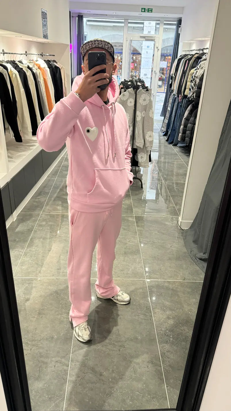 Selfie-look du pull à capuche ADJ rose devant le miroir soulignant le relief du logo en éponge.