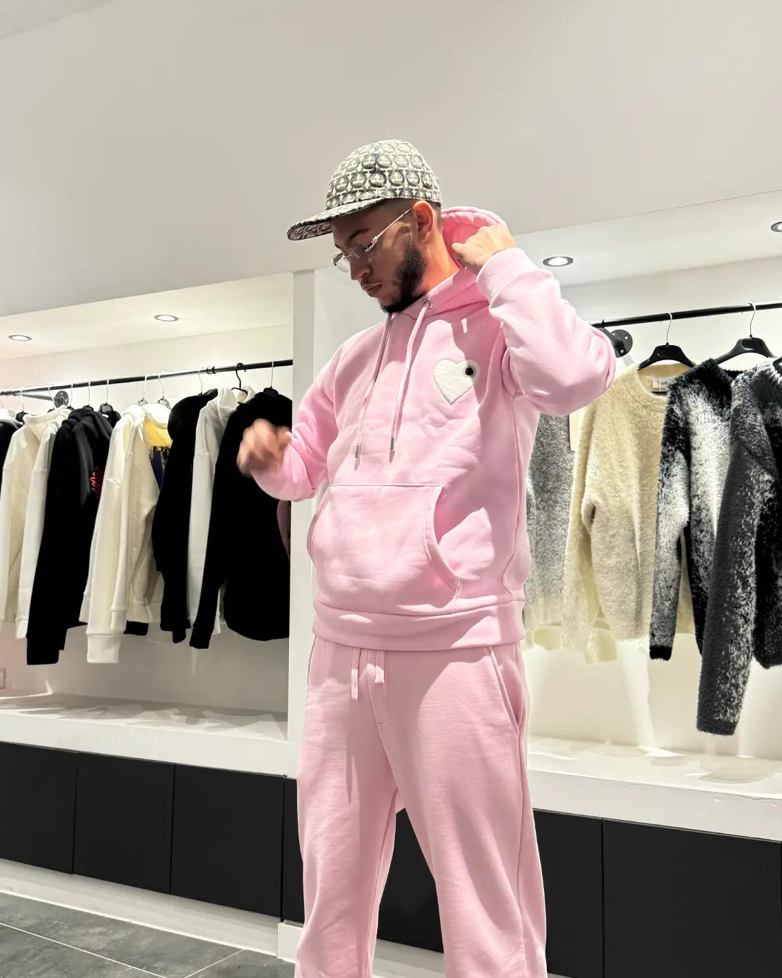 Modèle debout montrant la coupe classique et la shape équilibrée du pull ADJ rose en plein pied.