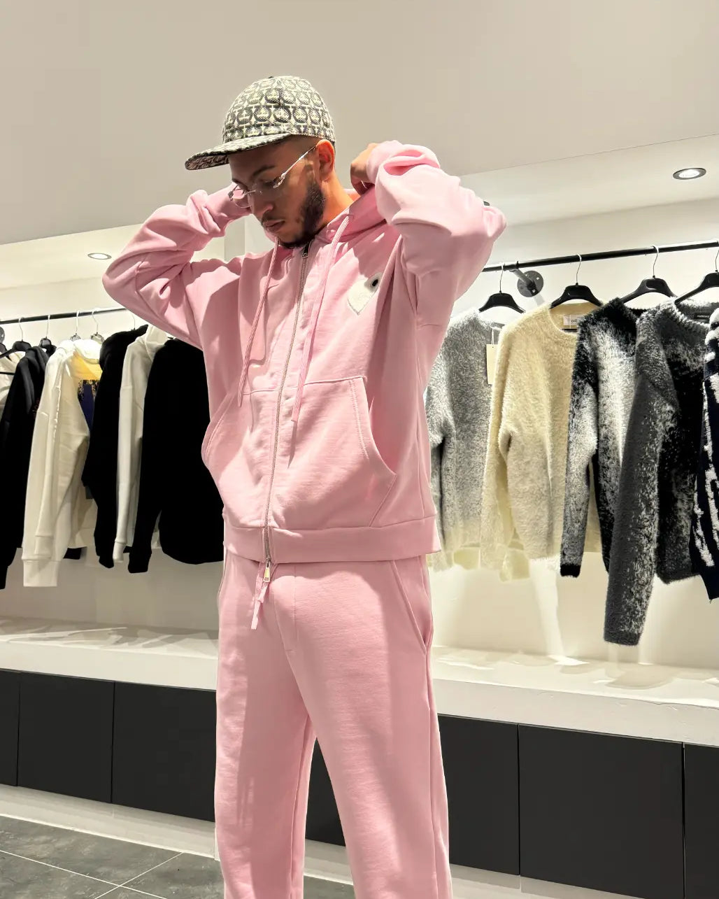 Modèle debout présentant la shape et la coupe classique du zipper hoodie ADJ rose en vue d'ensemble.