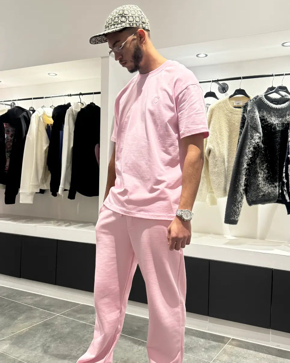 Vue d'ensemble du modèle debout montrant la coupe regular fit et le tombé impeccable du t-shirt ADJ rose.