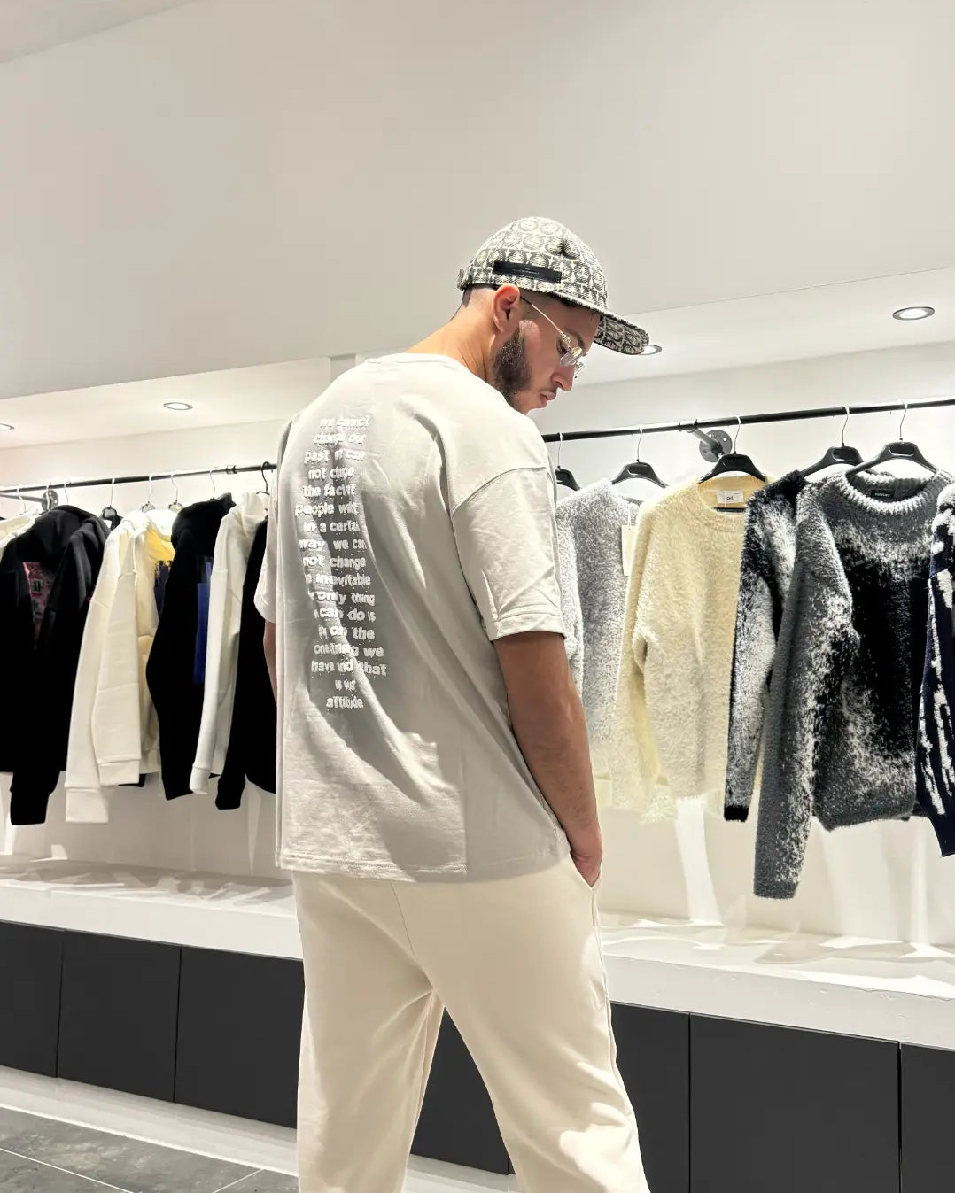 Focus sur le dos du modèle mettant en valeur le large print blanc Attitude sur le t-shirt gris.