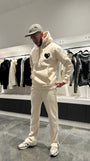 Modèle debout portant le pull ADJ beige révélant la shape complète et le tombé de la coupe classique.
