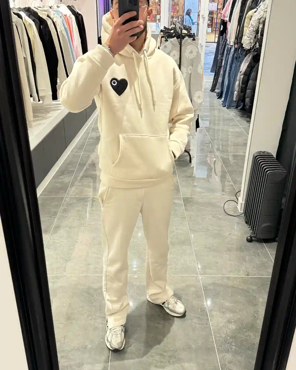 Selfie-look du pull ADJ beige devant le miroir mettant en avant le relief du cœur noir brodé.