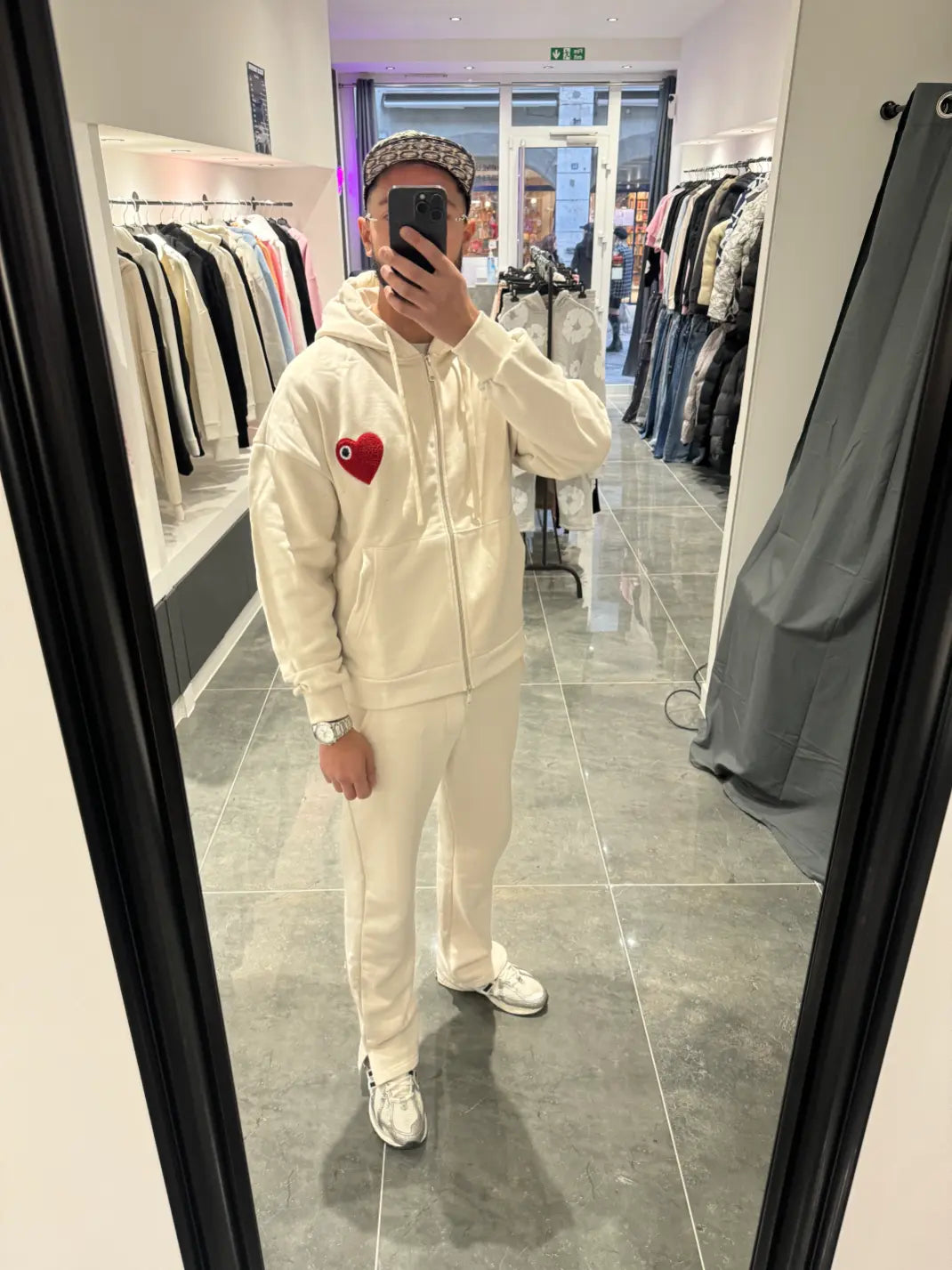 Selfie-look du gilet à capuche ADJ beige mettant en relief le logo cœur rouge en éponge.