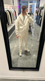 Selfie-look reflétant la broderie puff en relief sur le gilet à capuche zippé ADJ beige.