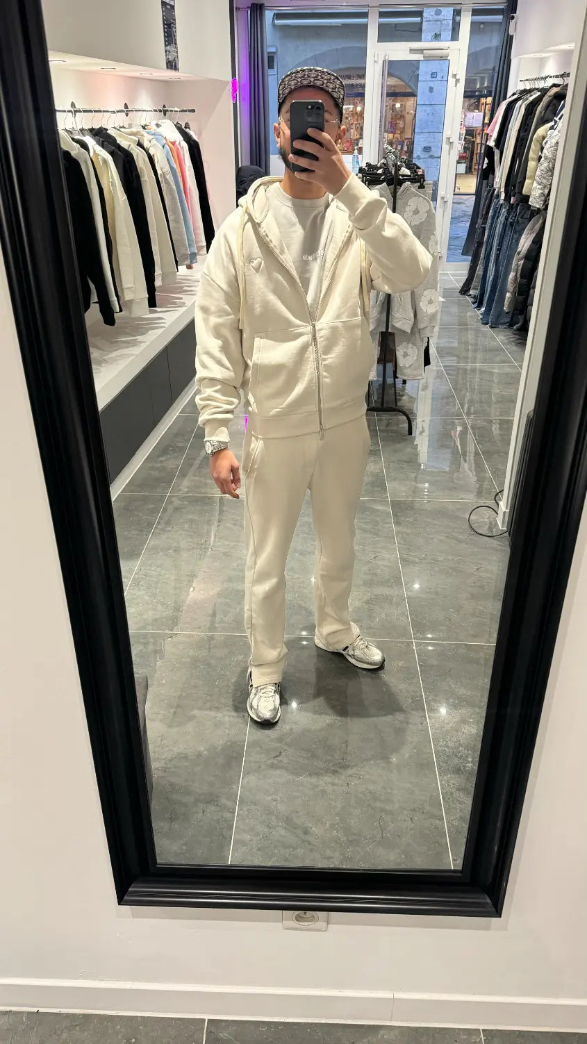 Selfie-look reflétant la broderie puff en relief sur le gilet à capuche zippé ADJ beige.