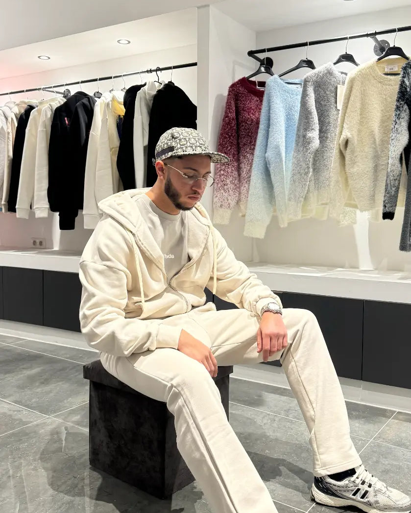 Pose décontractée du modèle assis portant le gilet ADJ beige en coton épais mettant en avant le confort.