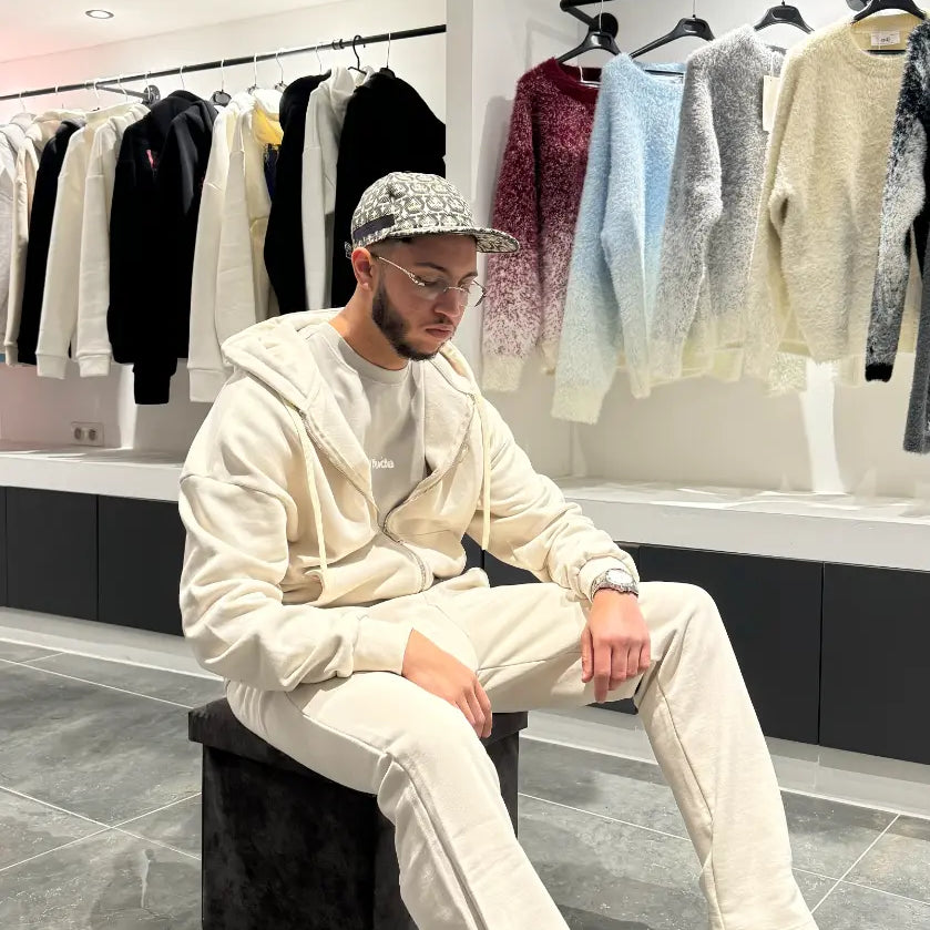 Pose décontractée du modèle assis portant le gilet ADJ beige en coton épais mettant en avant le confort.