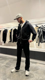 Modèle debout mettant en avant le style urbain et la finition premium du gilet à capuche noir ADJ.