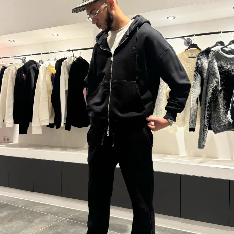 Modèle debout mettant en avant le style urbain et la finition premium du gilet à capuche noir ADJ.