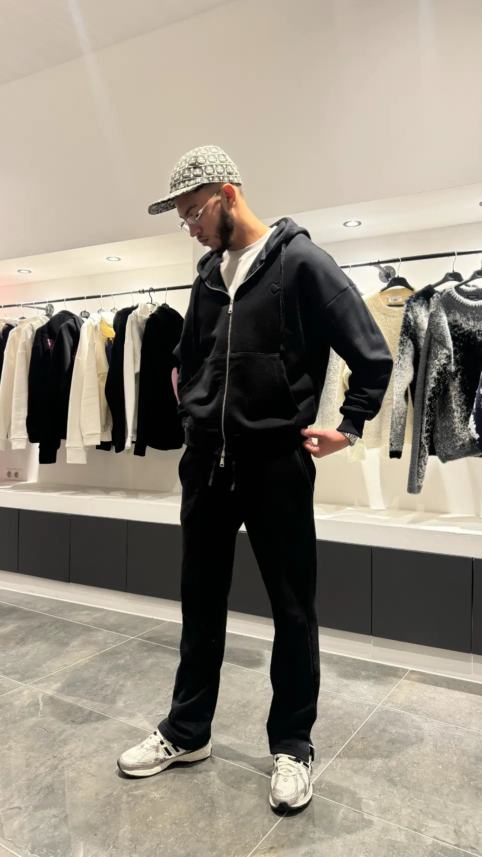Modèle debout mettant en avant le style urbain et la finition premium du gilet à capuche noir ADJ.