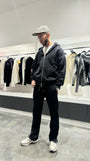 Silhouette complète montrant le tombé lourd et la shape regular fit du gilet noir ADJ en extérieur.
