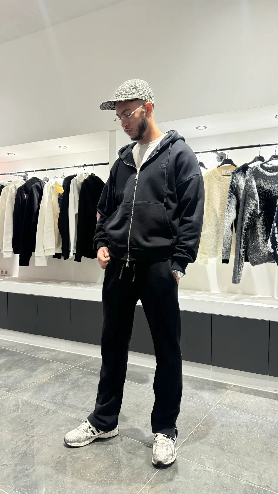 Silhouette complète montrant le tombé lourd et la shape regular fit du gilet noir ADJ en extérieur.