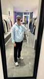 Selfie-look du gilet à capuche bleu clair ADJ mettant en avant la broderie du cœur blanc.