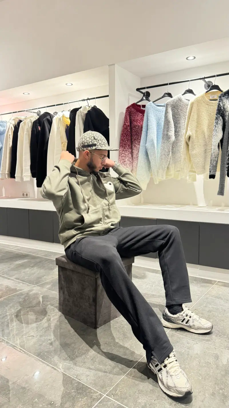 Gilet ADJ vert foncé ouvert sur t-shirt, cœur blanc brodé bien visible, attitude décontractée et clean.