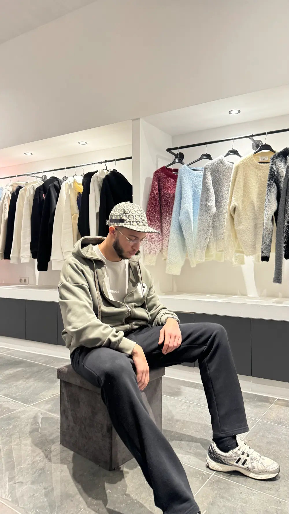 Modèle assis portant le gilet vert foncé ADJ mettant en valeur le contraste avec le cœur blanc.