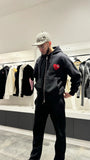 Silhouette complète du modèle debout présentant le tombé lourd et la shape du gilet noir.