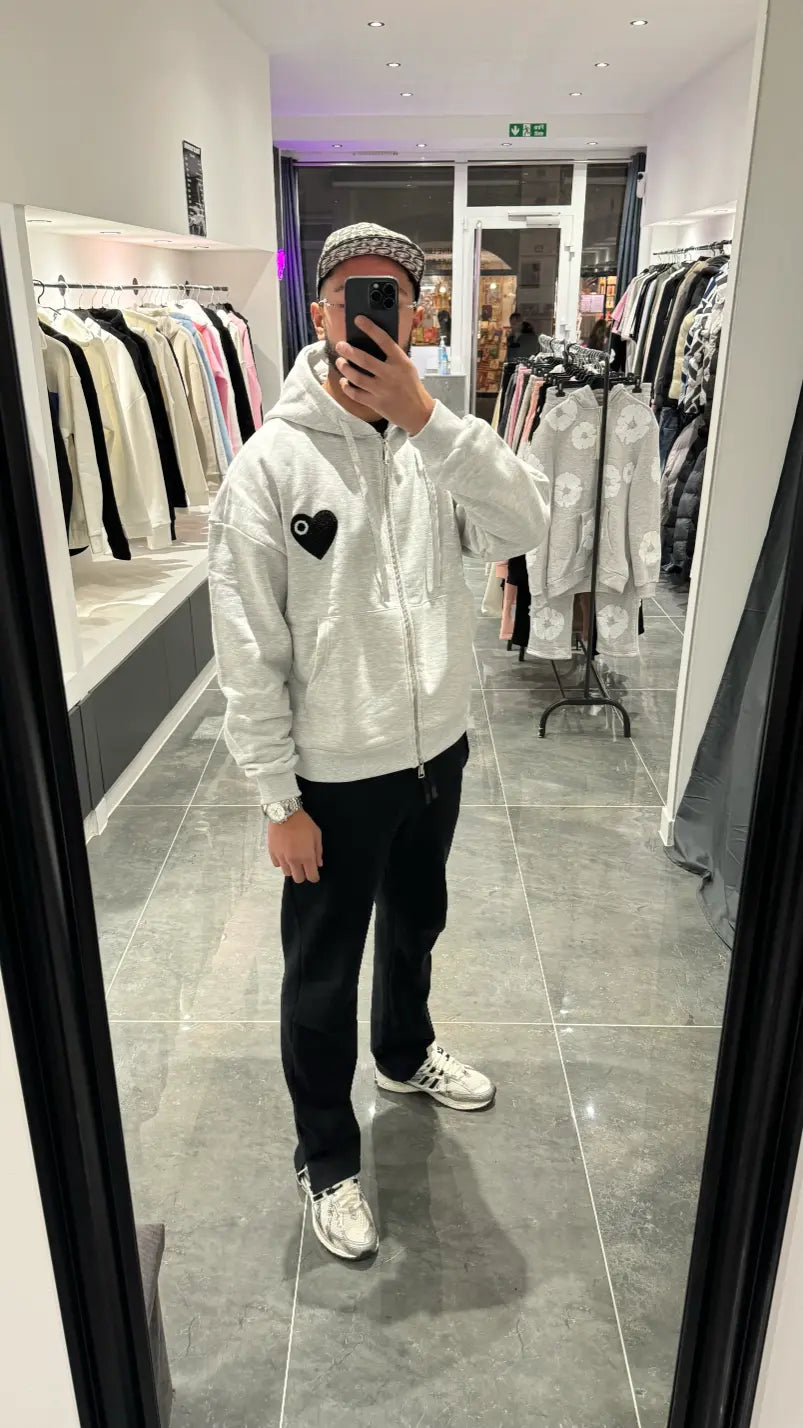 Selfie-look reflétant la broderie noire sur le gilet à capuche gris chiné ADJ.