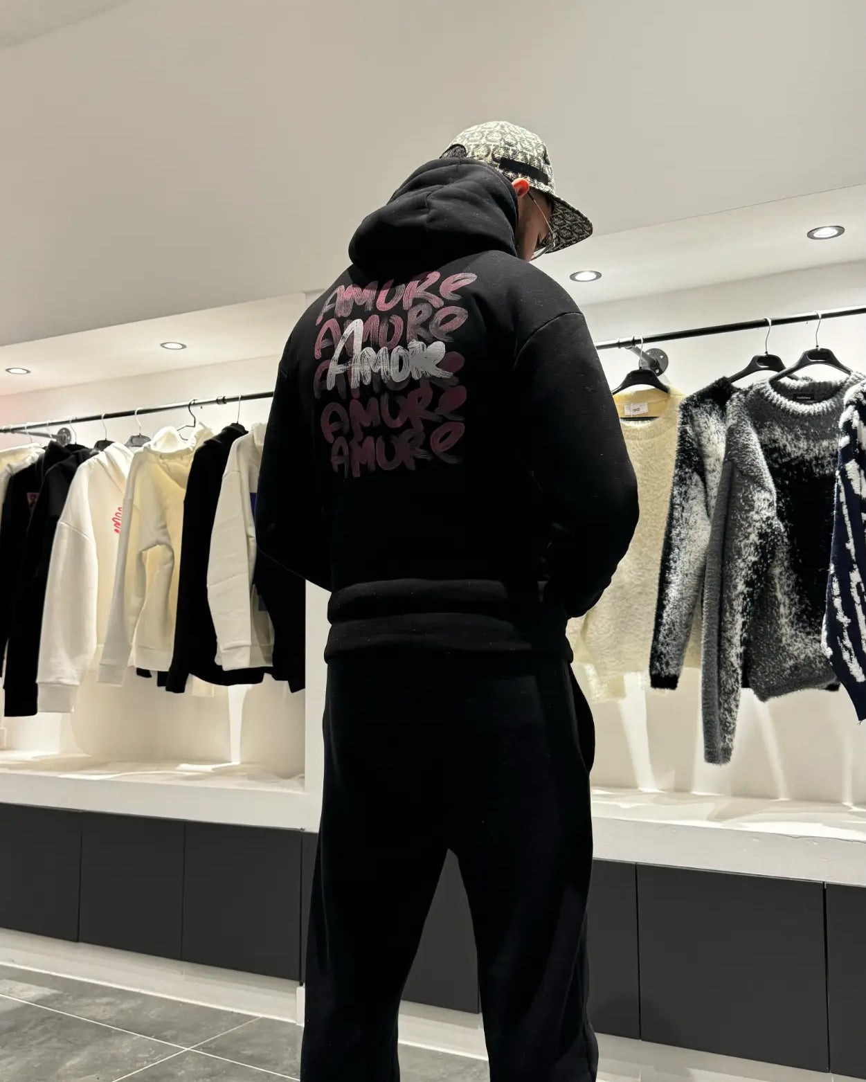 Focus sur le dos du modèle révélant l'accumulation des prints Amore au style rouge à lèvres.