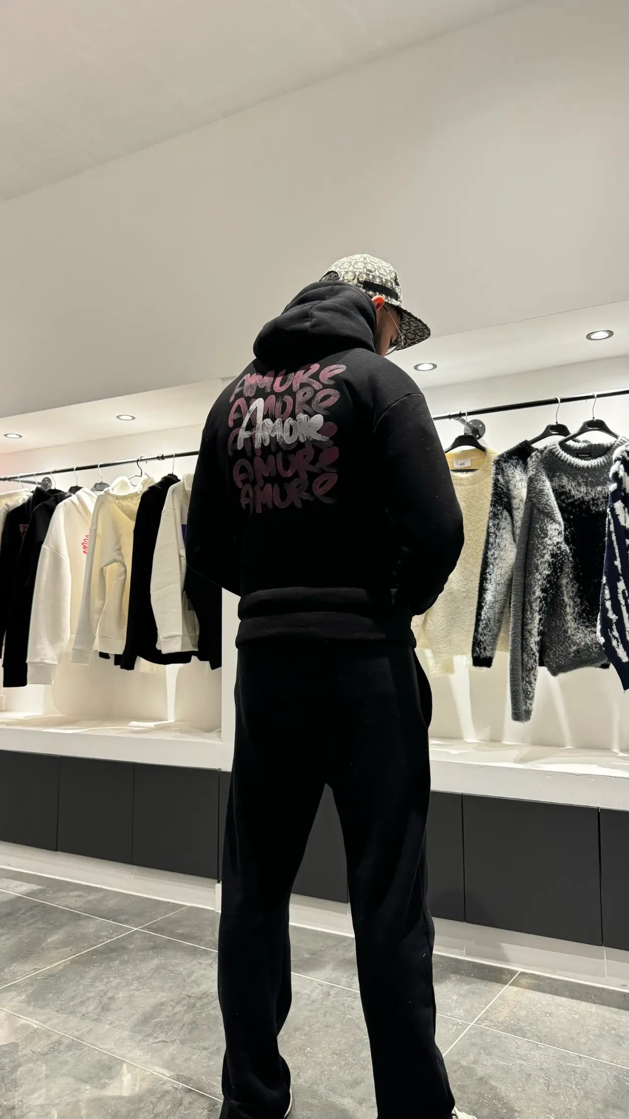 Focus sur le dos du modèle révélant l'accumulation des prints Amore au style rouge à lèvres.