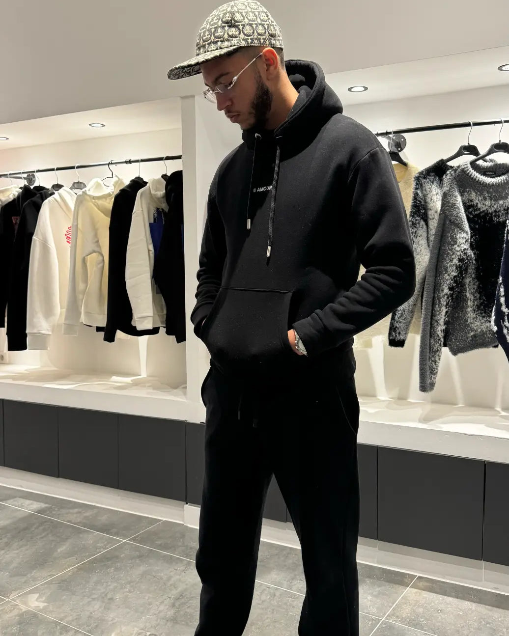 Silhouette complète du modèle debout montrant la shape moderne et le style graphique du pull noir ADJ.