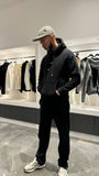 Silhouette complète du modèle debout montrant la shape moderne et le style graphique du pull noir ADJ.