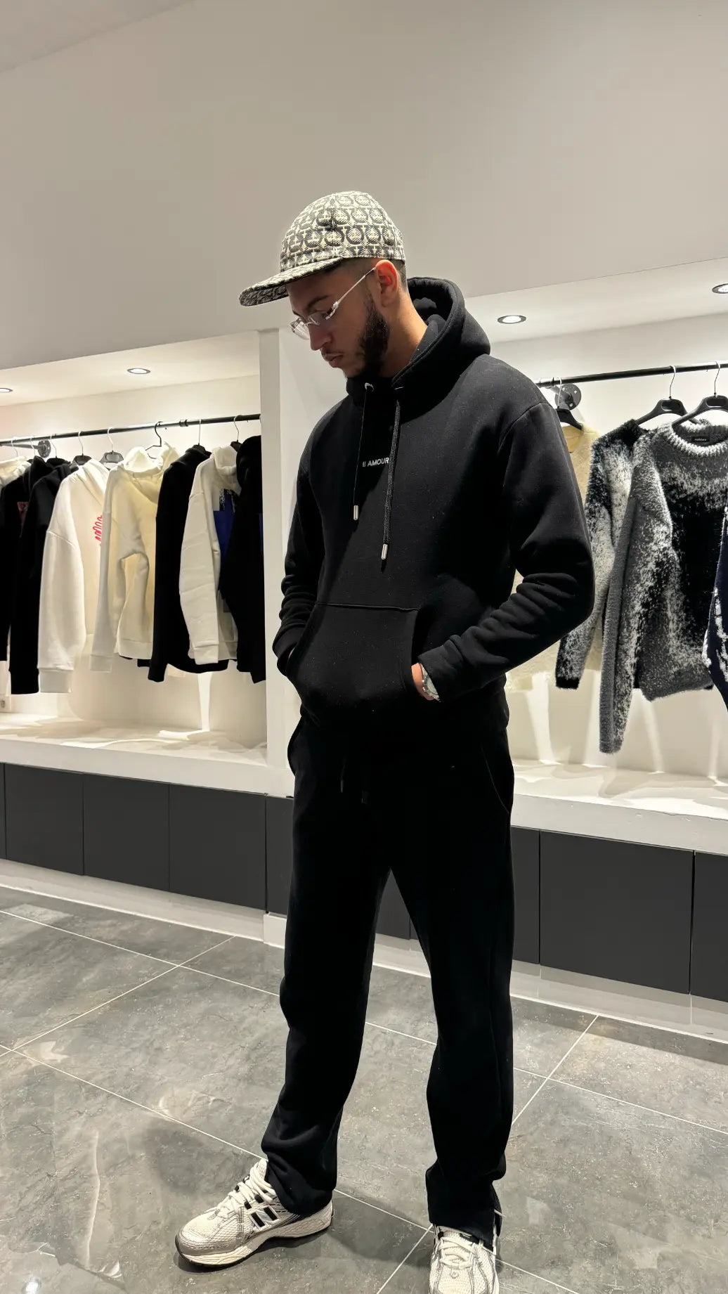 Silhouette complète du modèle debout montrant la shape moderne et le style graphique du pull noir ADJ.