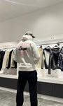 Focus sur les écritures amore au style rouge à lèvres au dos du pull blanc ADJ.