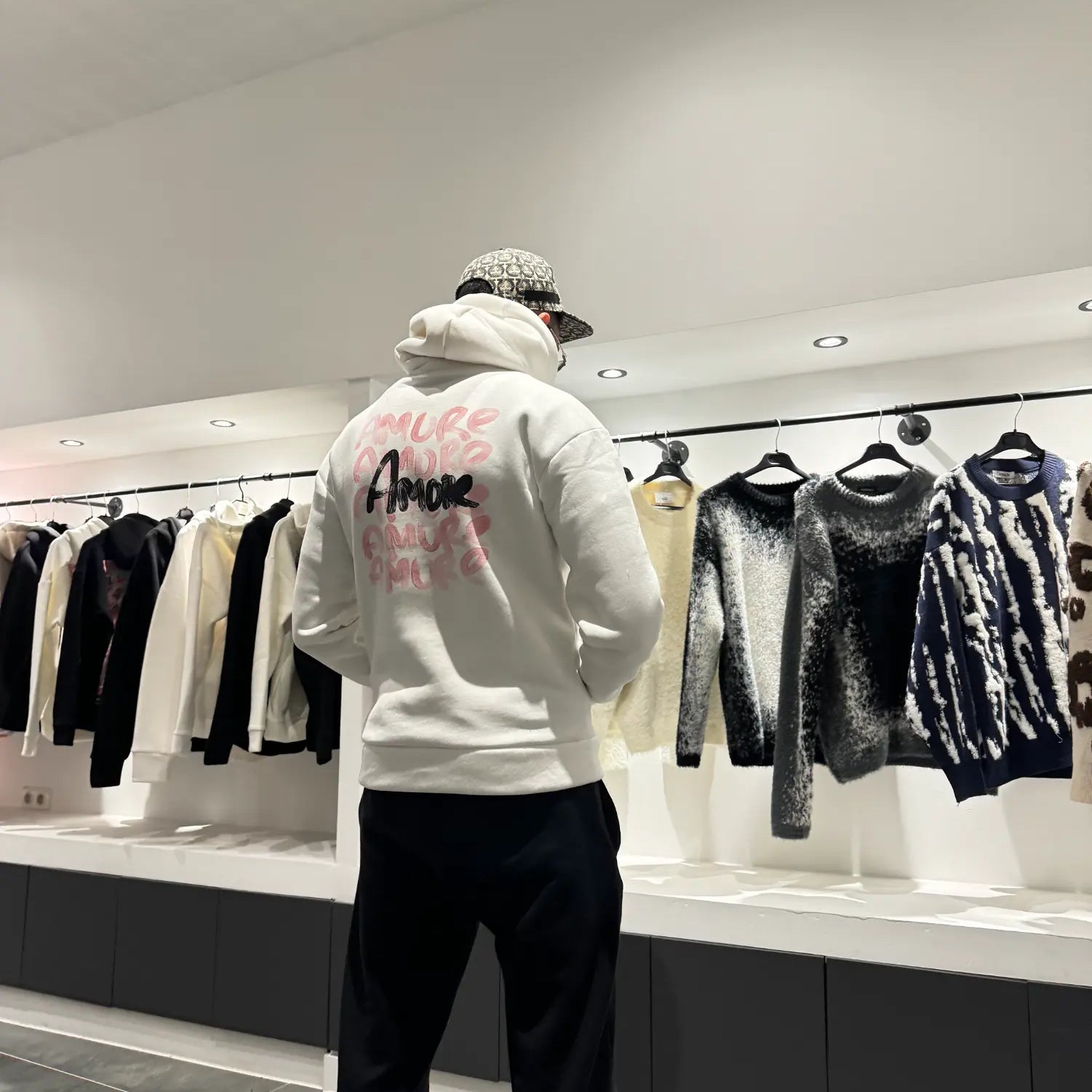 Focus sur les écritures amore au style rouge à lèvres au dos du pull blanc ADJ.