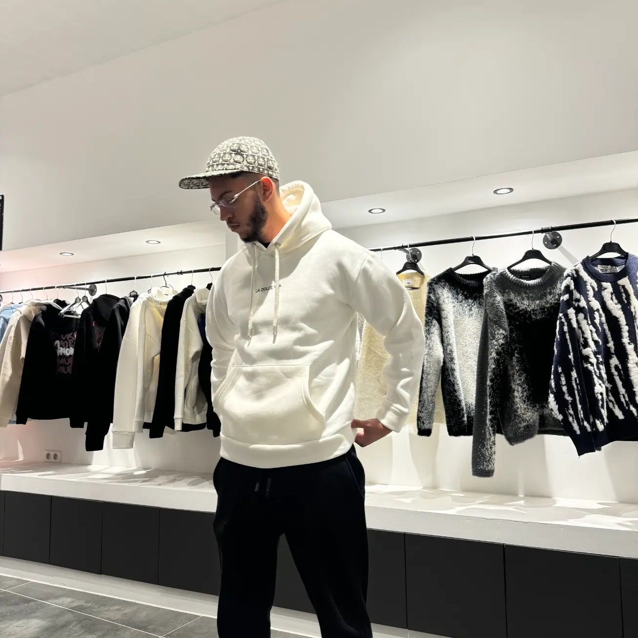 Silhouette complète montrant le tombé droit et le style épuré du pull blanc ADJ.