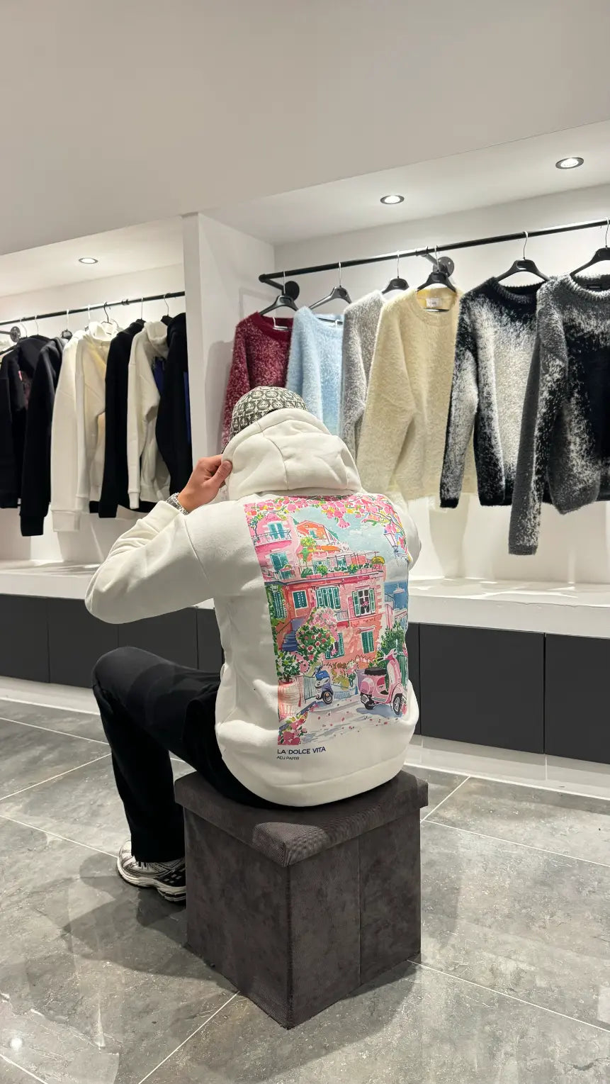 Focus sur le dessin graphique de Paris au trait noir sur le dos du pull blanc ADJ.