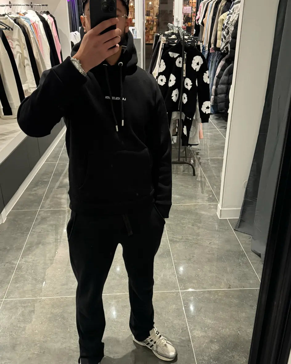 Selfie-look reflétant la coupe classique et le tombé du pull noir ADJ en coton.