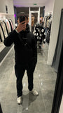 Selfie-look reflétant la coupe classique et le tombé du pull noir ADJ en coton.