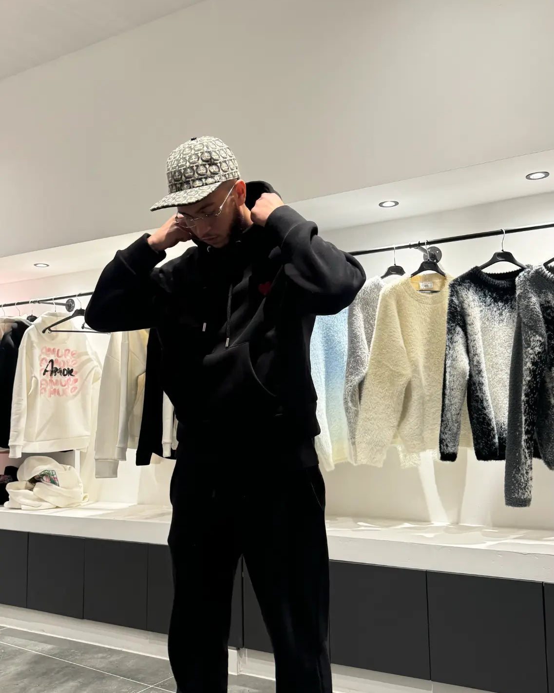 Silhouette complète montrant le tombé large et le style décontracté du pull noir ADJ.