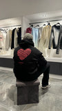 Focus sur l'arrière du modèle révélant le grand Love Heart Print rouge avec l'inscription Amore au centre du dos.