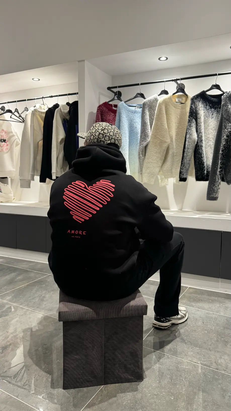 Focus sur l'arrière du modèle révélant le grand Love Heart Print rouge avec l'inscription Amore au centre du dos.