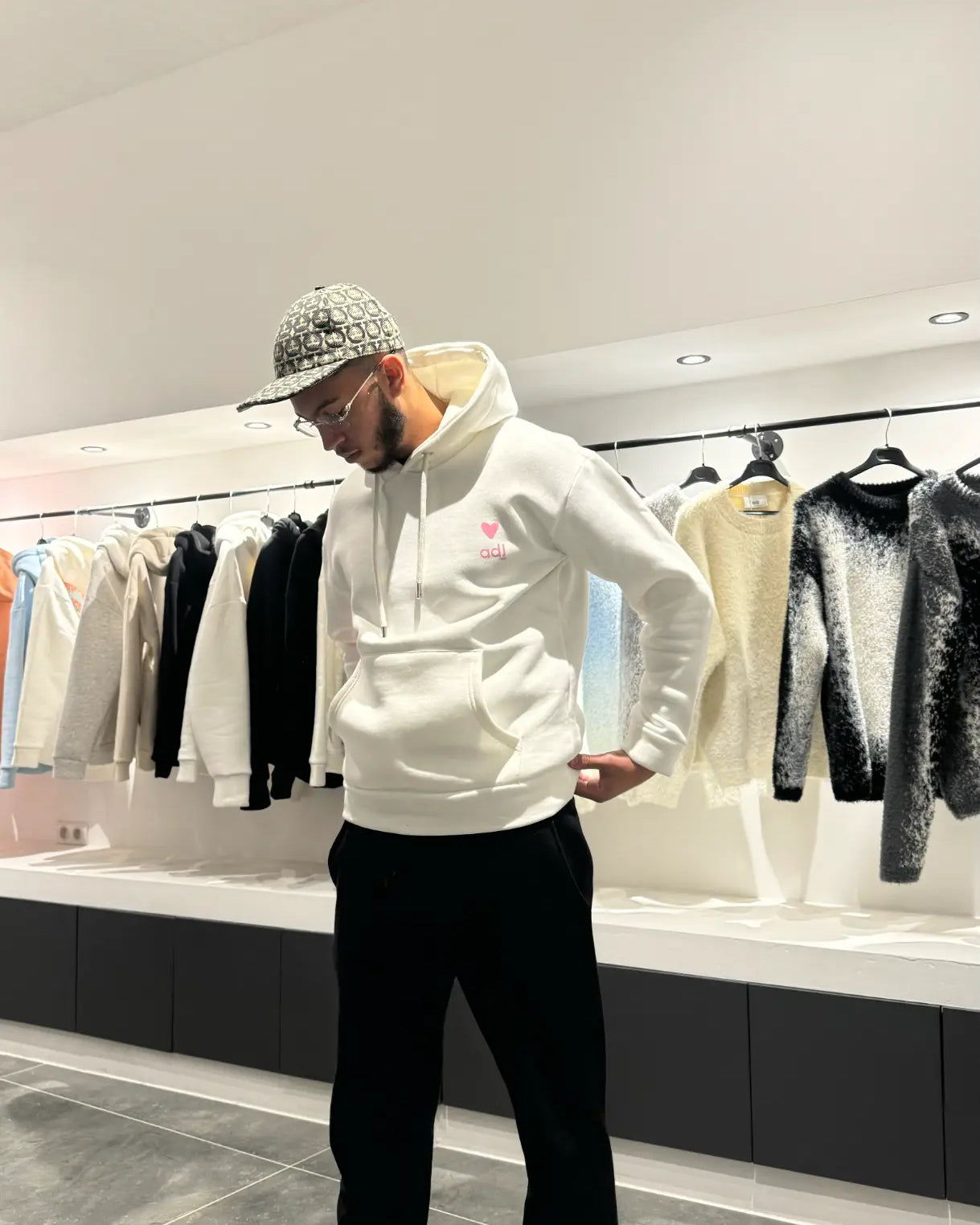 Silhouette complète du modèle debout présentant la shape et le tombé impeccable du pull blanc ADJ.