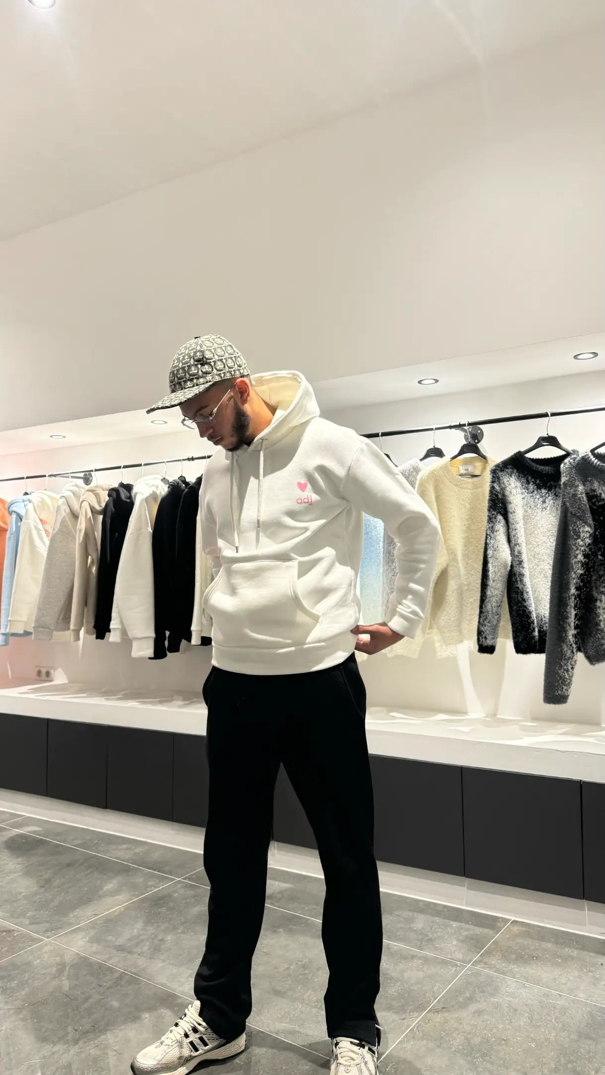 Silhouette complète du modèle debout présentant la shape et le tombé impeccable du pull blanc ADJ.