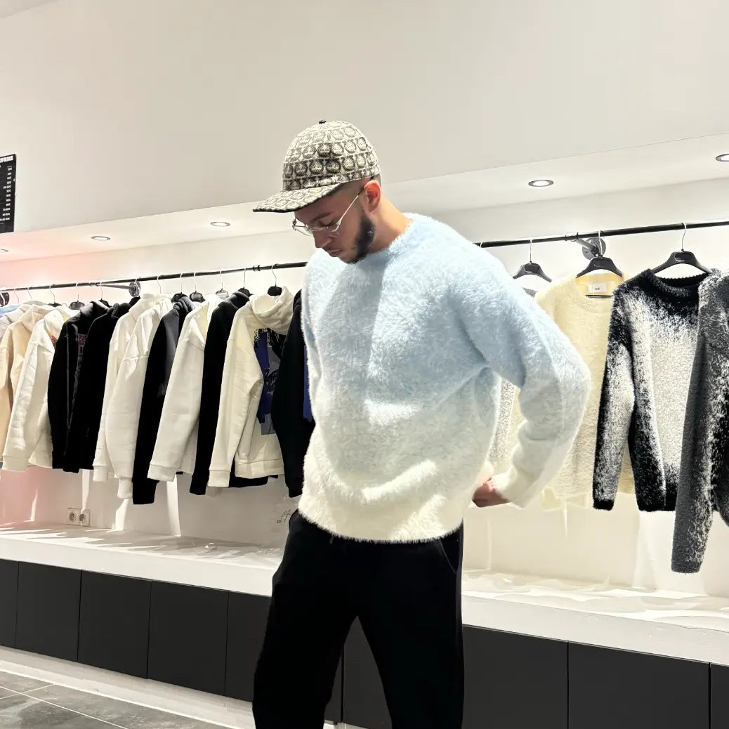 Silhouette complète montrant le tombé impeccable et la coupe structurée du pull en maille bleu clair.