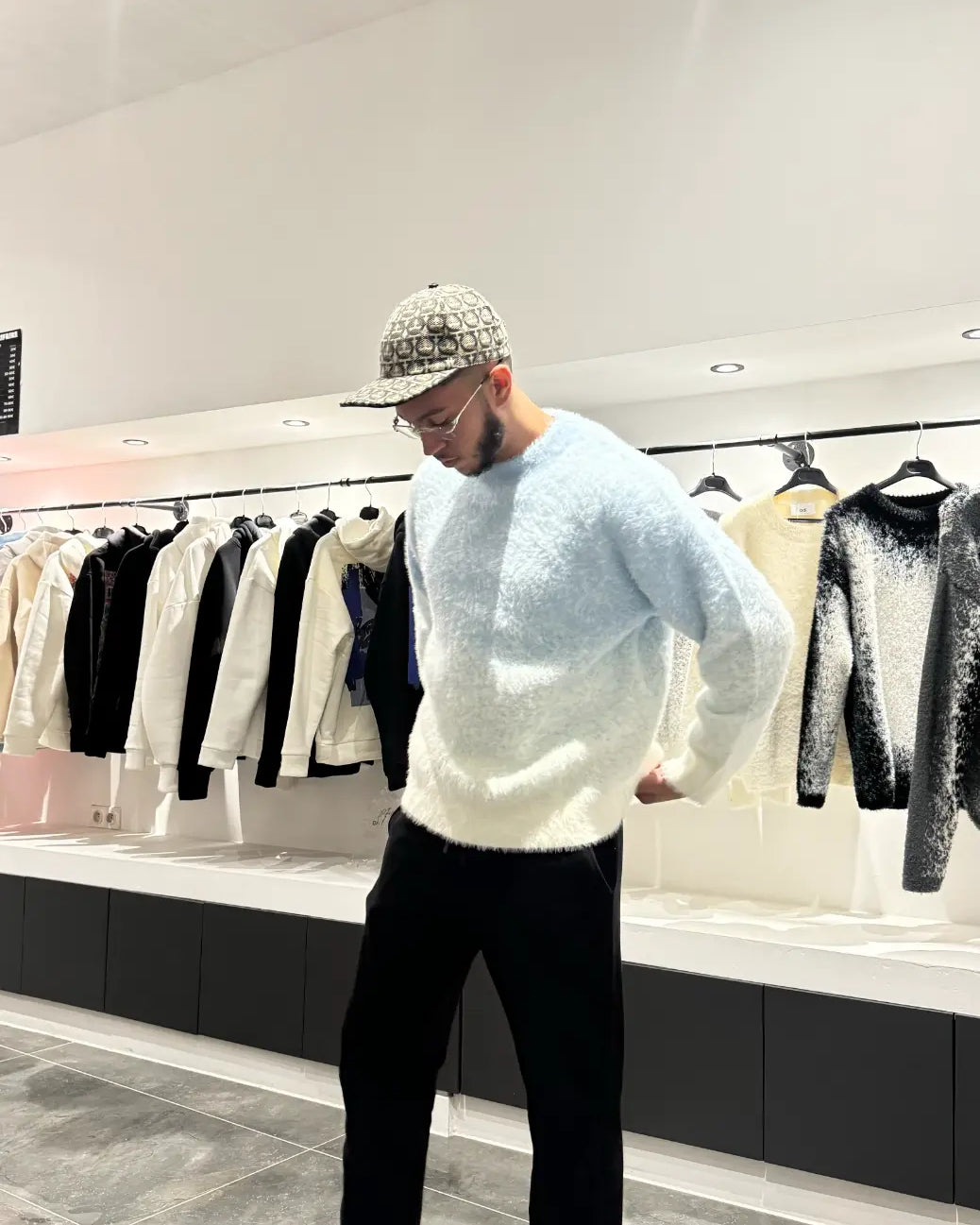 Silhouette complète montrant le tombé impeccable et la coupe structurée du pull en maille bleu clair.