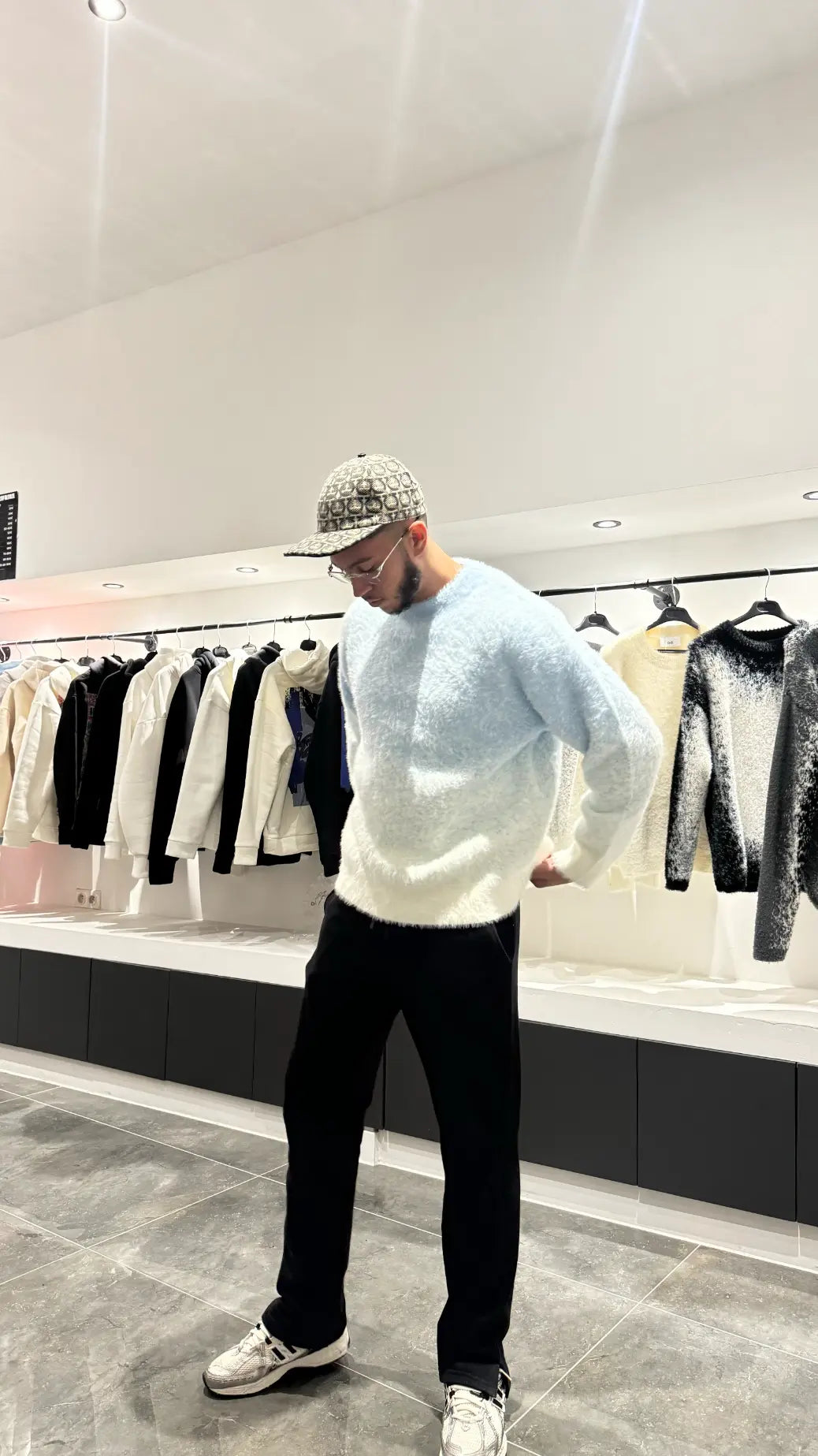 Silhouette complète montrant le tombé impeccable et la coupe structurée du pull en maille bleu clair.