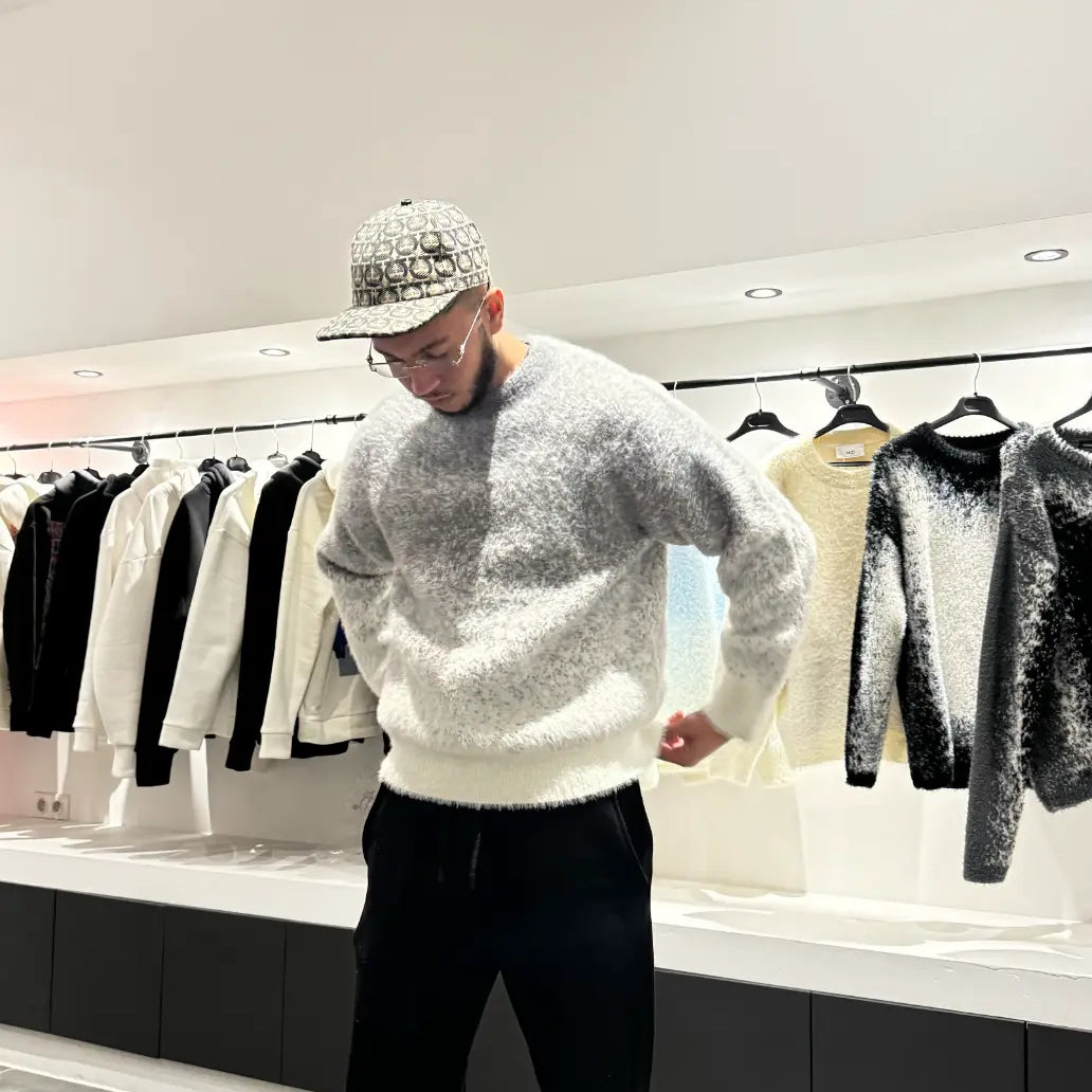 Silhouette nette du modèle debout présentant le pull en maille épaisse gris chiné.